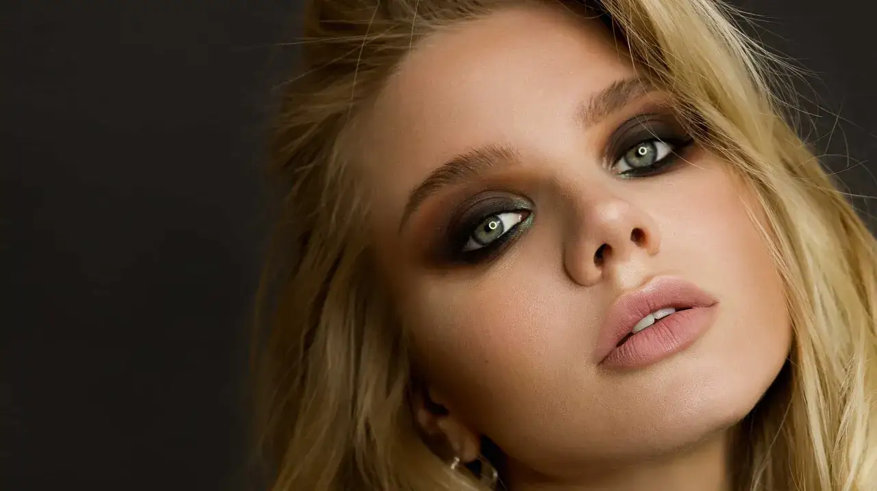 Un regard intense, des yeux verts perçants soulignés d'un maquillage smoky, des lèvres rosées.