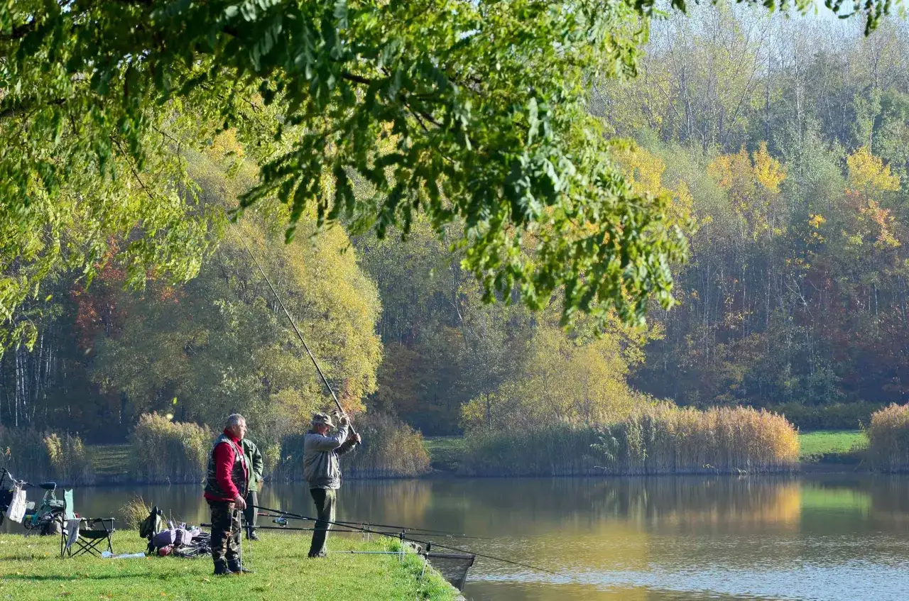 Jesień nad **doliną trzech stawów**. Wędkarze łowią ryby na tle kolorowych drzew.
