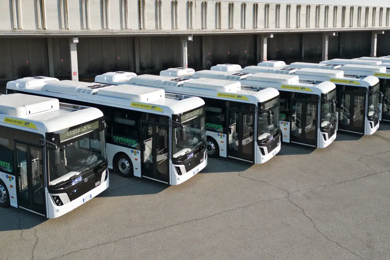 Flotta di autobus bianchi parcheggiati, pronti per il servizio. Le imprese pubbliche come GTT garantiscono la mobilit&agrave;.