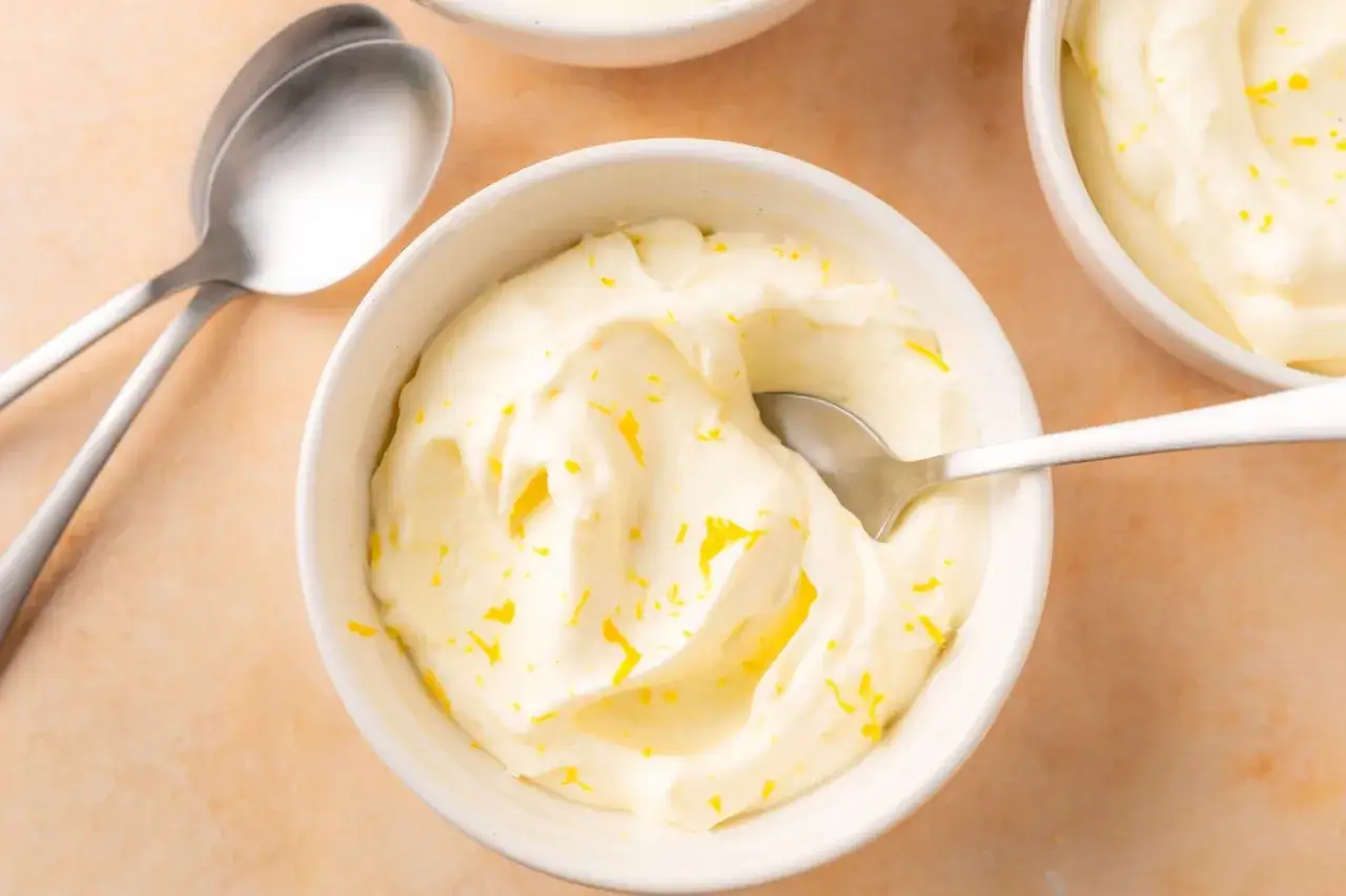 Delicioso mousse de limón, cremoso y refrescante, adornado con ralladura de limón.