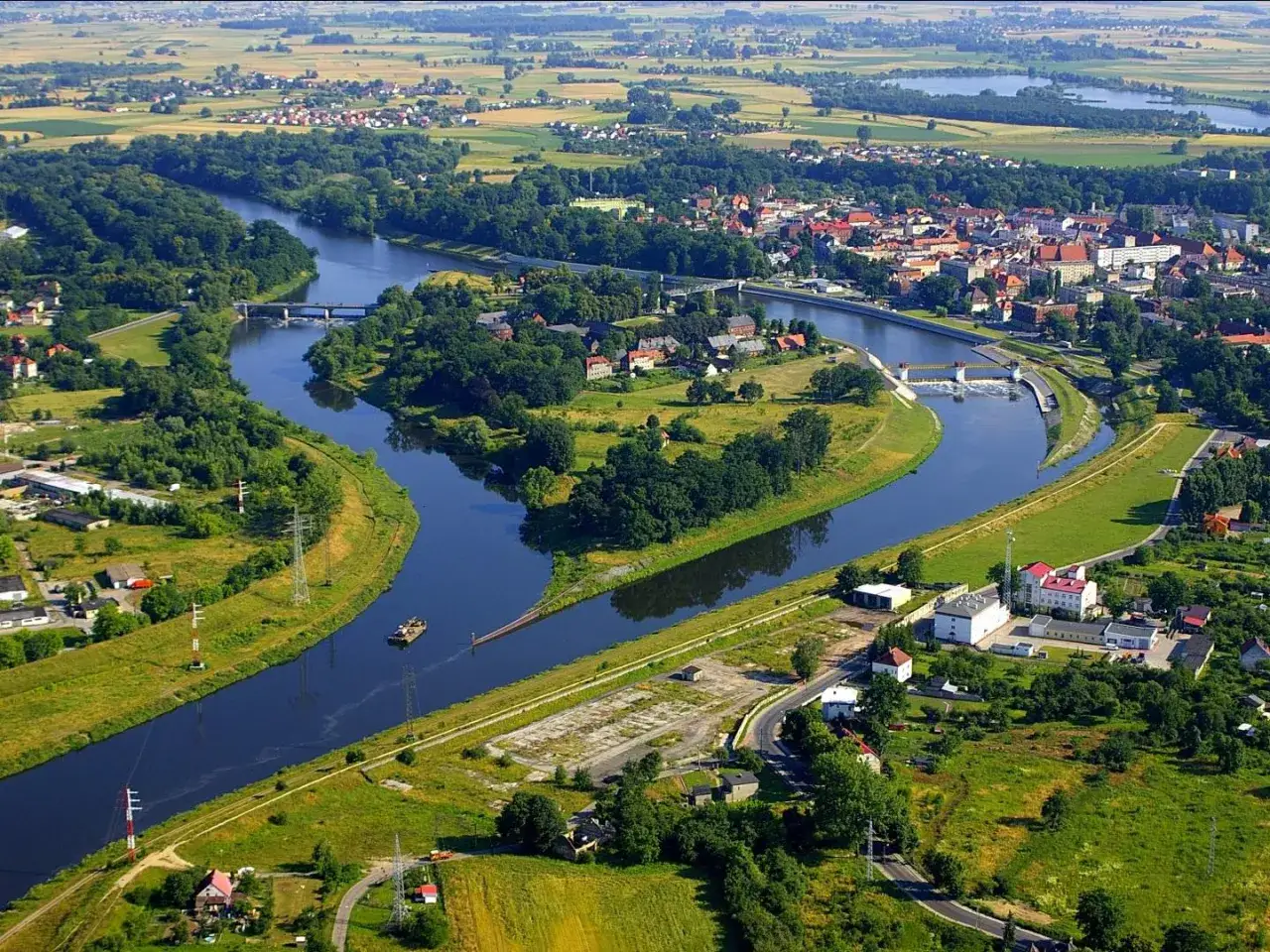 Widok z lotu ptaka na Kędzierzyn-Koźle, z rzeką, mostami i zabudowaniami. Odkryj kędzierzyn koźle atrakcje!