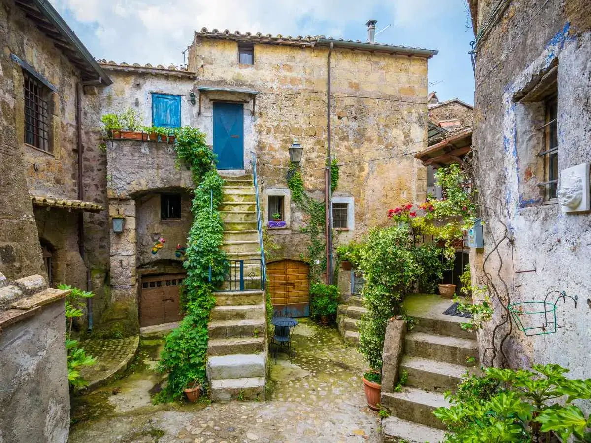 Un cortile antico con scale di pietra ricoperte di edera, dove si dice che le streghe calcata si riunissero.