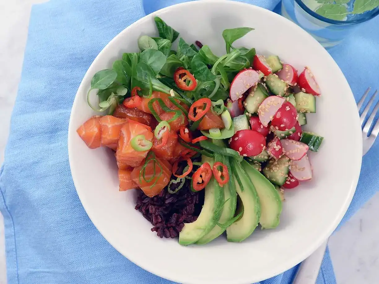 En skål med lax, avokado, grönsaker och svart ris. Ett perfekt svart ris recept för en hälsosam lunch.