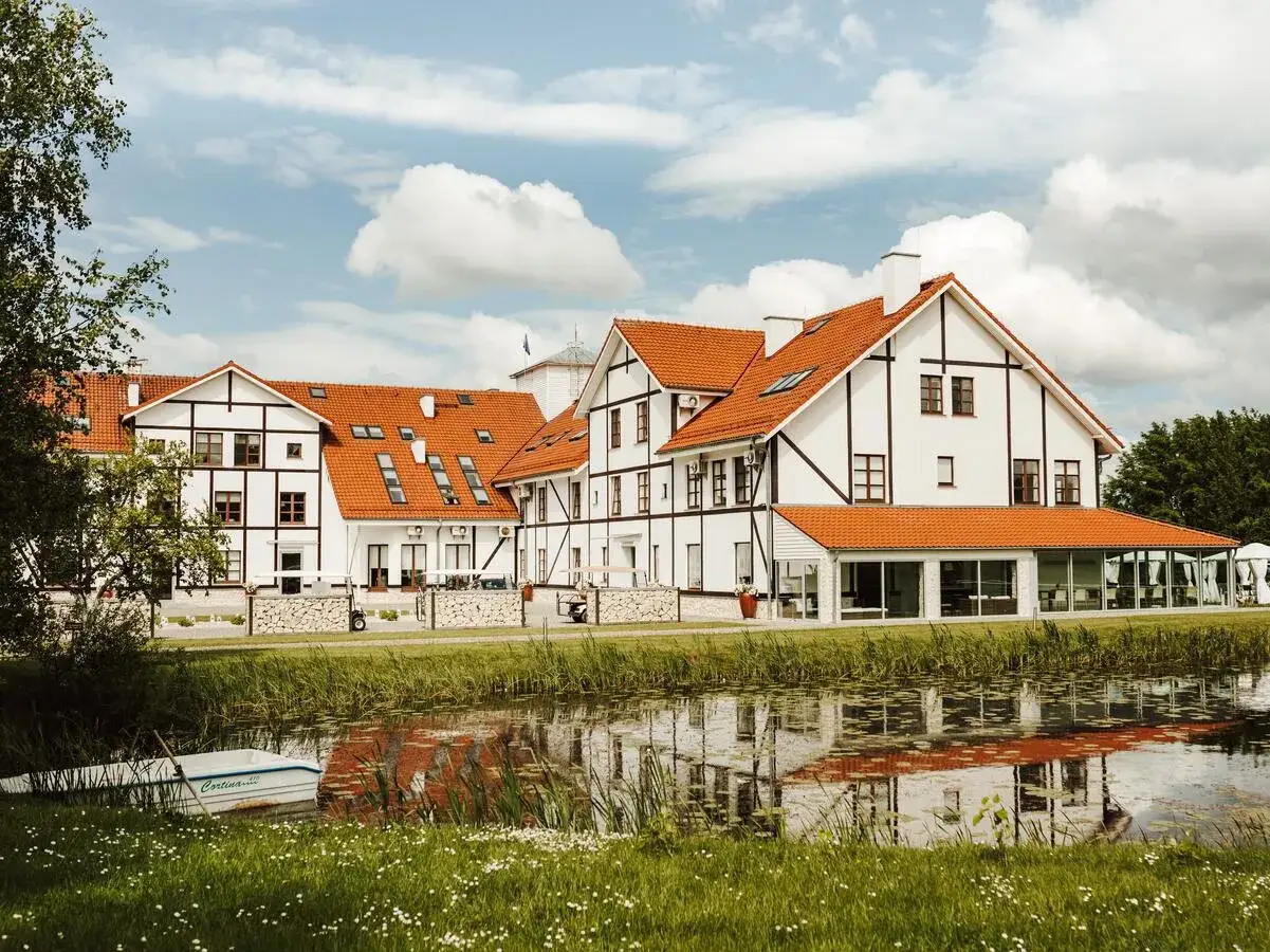 Malowniczy widok na Narie Resort & Spa z łódką przy brzegu i odbiciem w wodzie.