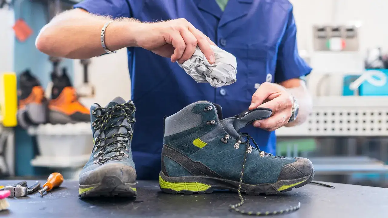 A person is carefully cleaning hiking boots, ensuring proper wanderschuhe pflegen for their next adventure.