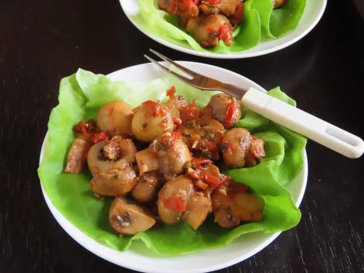 Champignons à la grecque, tendres et savoureux, servis sur des feuilles de laitue croquantes. Une bouchée fraîche et parfumée.