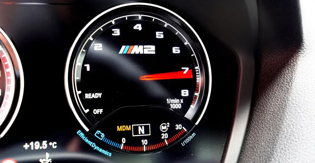 Obrotomierz BMW M2 pokazuje optymalne obroty silnika benzynowego, wskazując 7000 obr./min. Widoczny też wskaźnik temperatury +19.5°C.