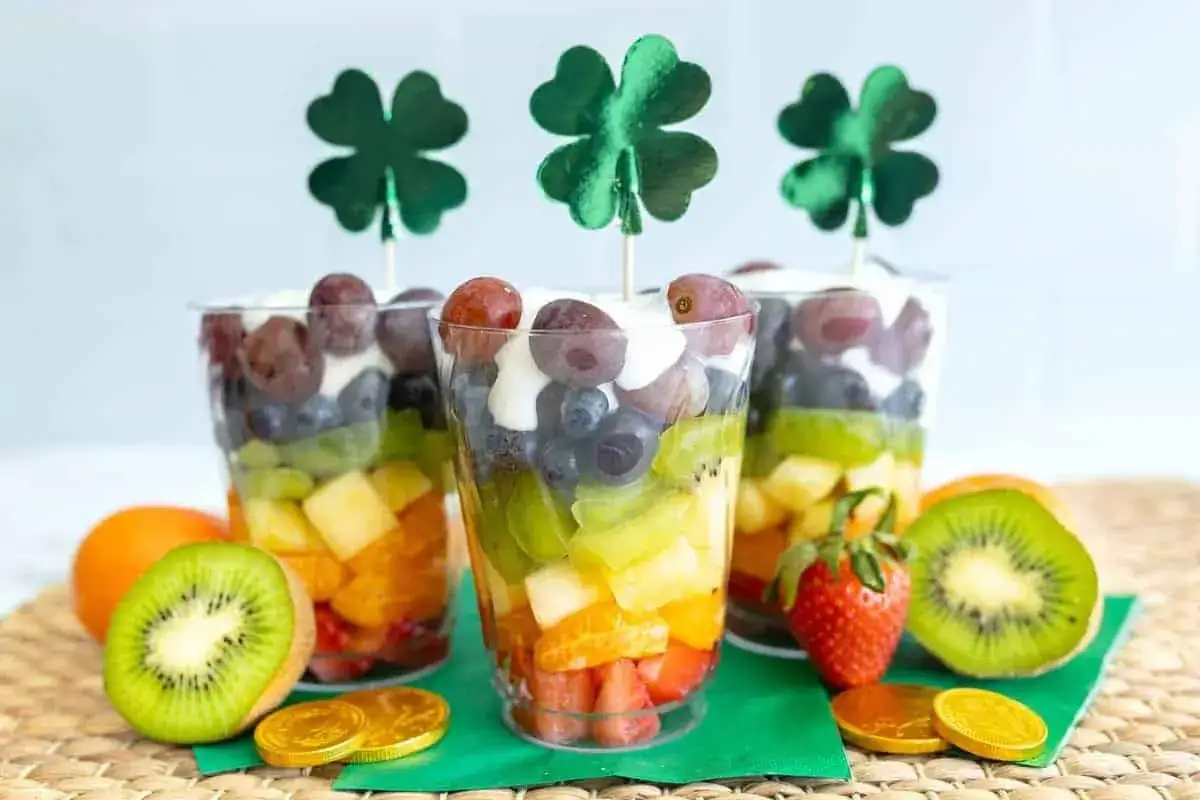 Bunte Fruchtbecher mit Kleeblatt-Deko, perfekt als kalorienarme Snacks f&uuml;r eine Feier.
