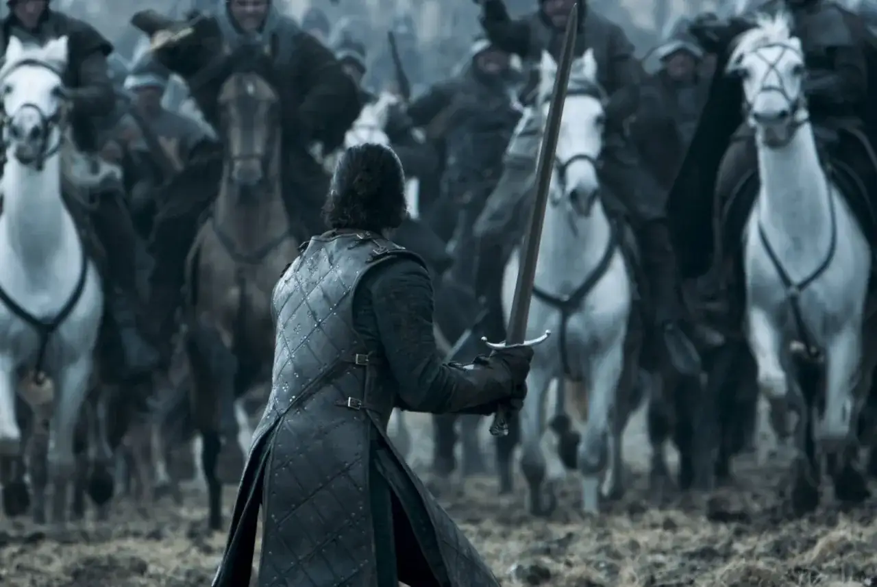 Jon Snow z mieczem w dłoni, na czele armii konnych wojowników, przygotowuje się do bitwy. Scena z