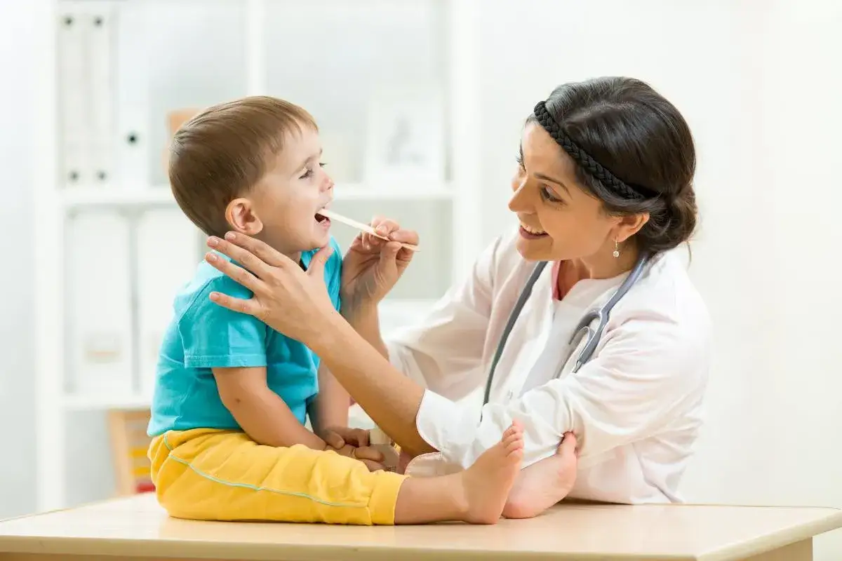 Laryngolog dziecięcy badający dziecko