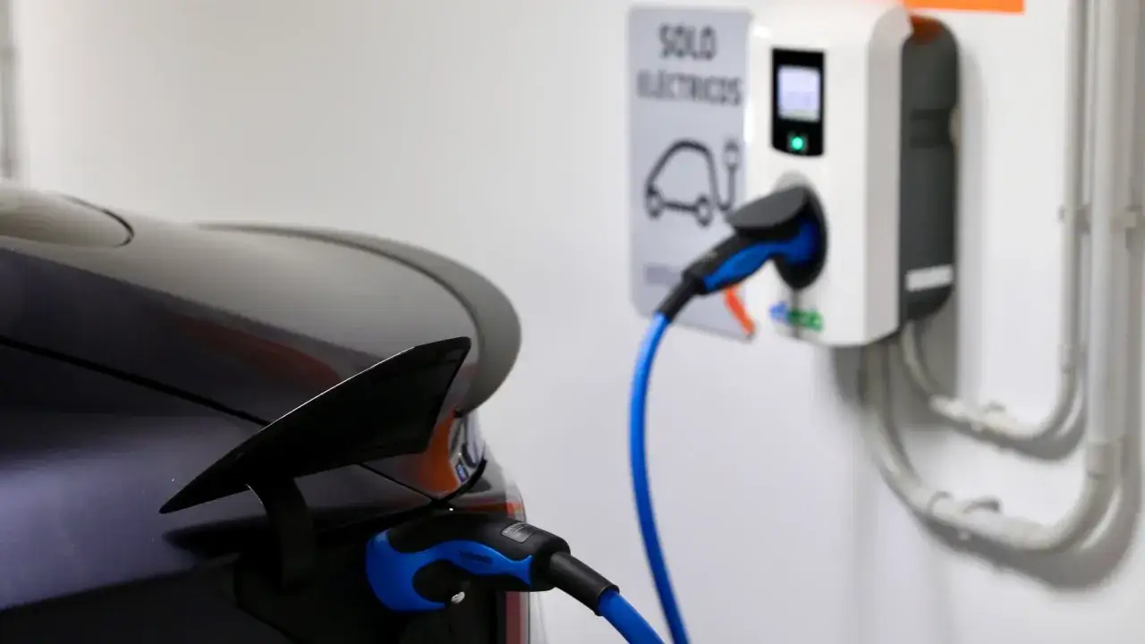 Cargando coche el&eacute;ctrico a 16 amperios. El conector azul se conecta al veh&iacute;culo, listo para la carga.