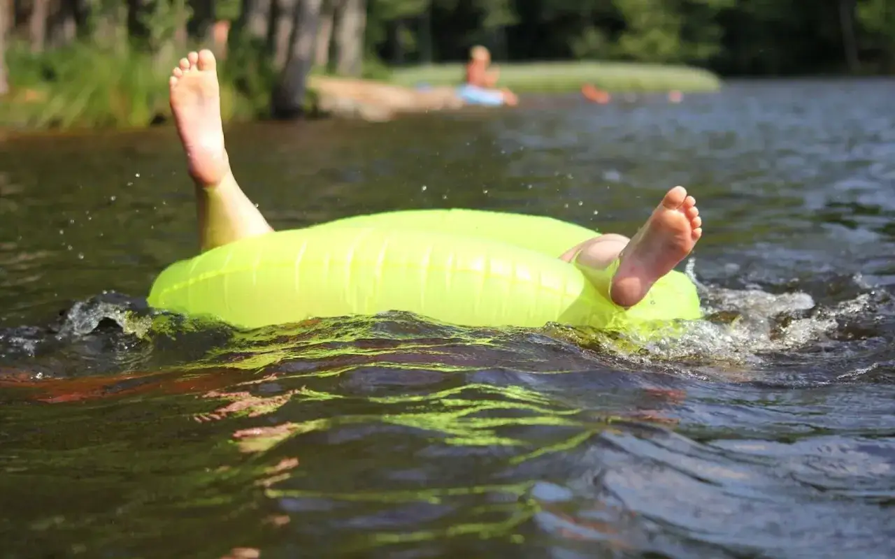 F&uuml;&szlig;e ragen aus einem gelben Schwimmring im Wasser. Ein entspannter Tag im Strandbad Hamburg.