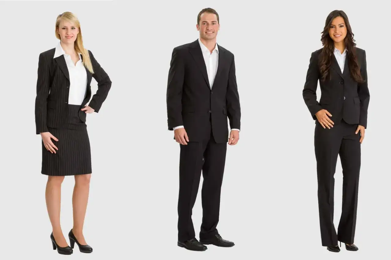 Drei Personen in Business-Casual-Kleidung: Frau im Nadelstreifen-Kost&uuml;m, Mann im schwarzen Anzug, Frau in schwarzer Hose und Blazer.