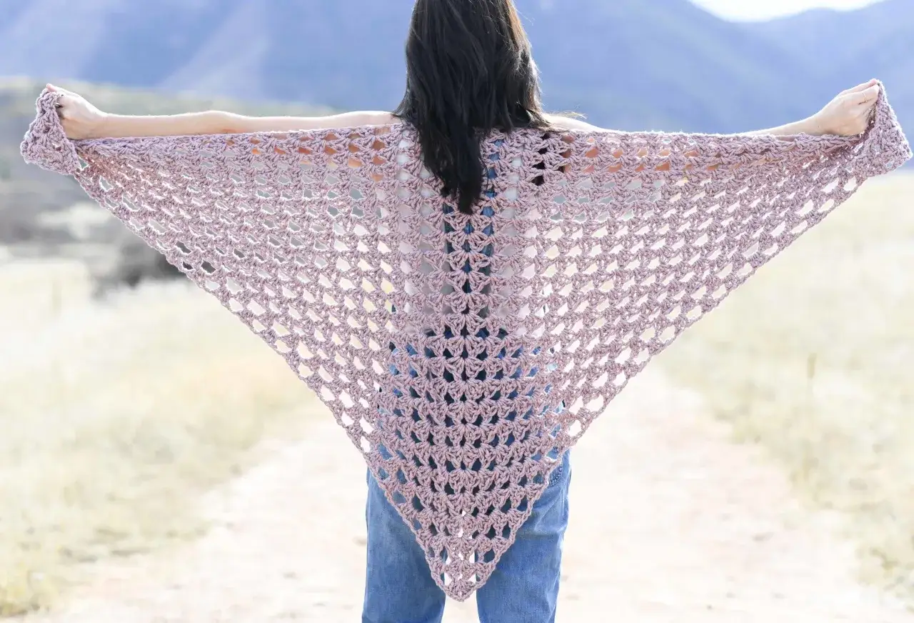 Chal triangular de crochet en tono rosa pálido, ideal para un patrón chal crochet facil.