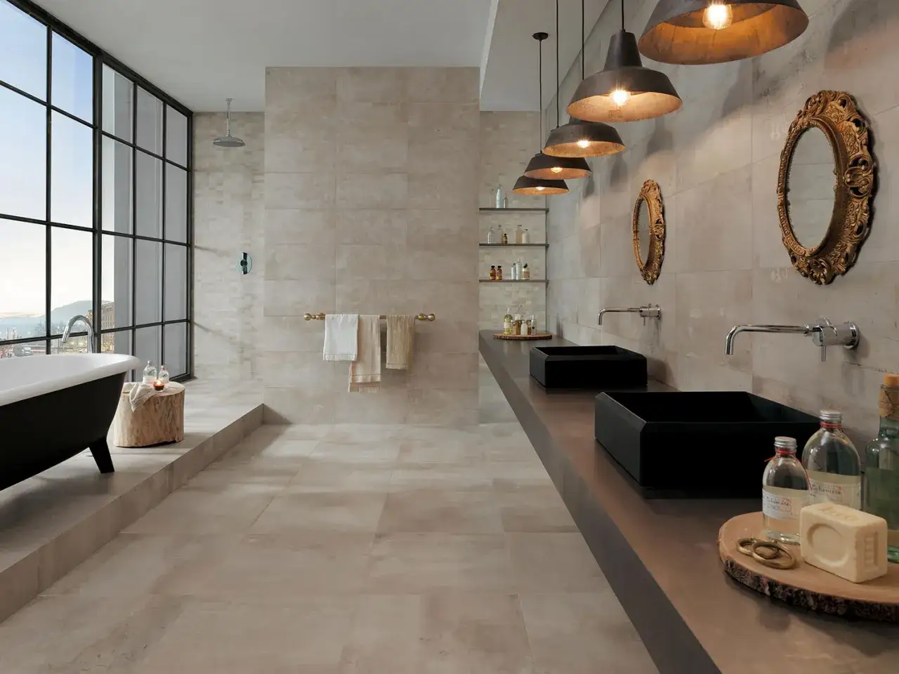 Salle de bain moderne avec baignoire îlot, double vasque noire et carrelage effet pierre. Parfait pour des travaux rénovation salle de bain.
