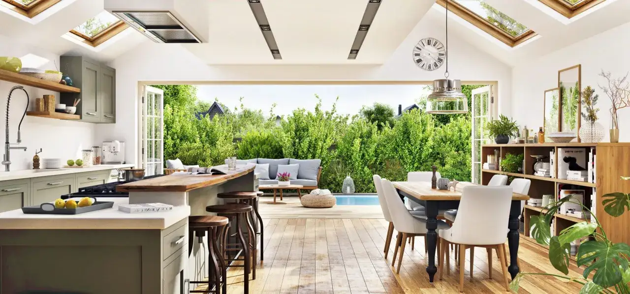 A bright, airy natural wood kitchen design opens to a lush garden and pool. Skylights flood the space with light, highlighting the warm wood tones and modern appliances.