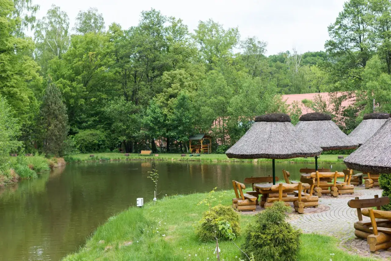Malownicze łowisko na wyspie Pokrzywna z drewnianymi stołami i wiatami. Idealne miejsce na relaks nad wodą.