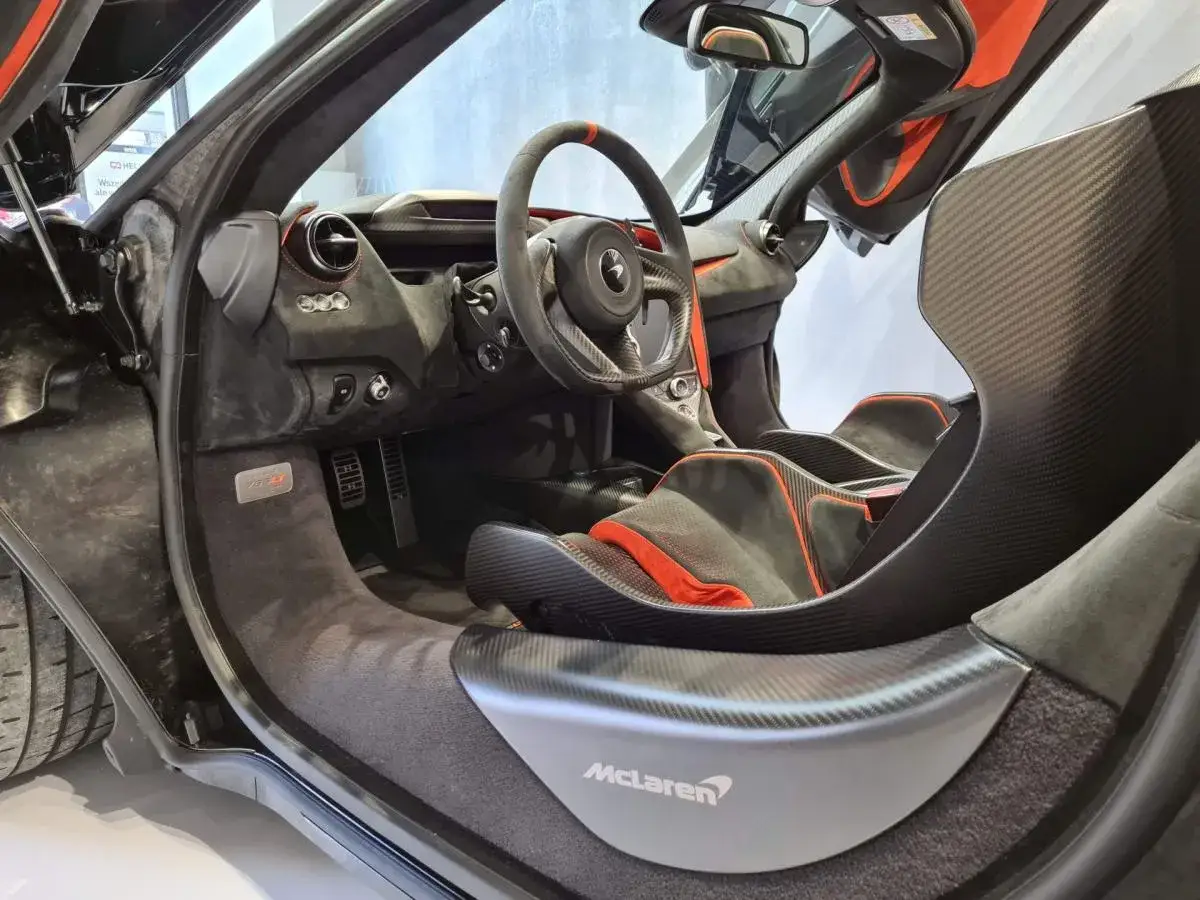 Wnętrze McLarena z pomarańczowymi akcentami i sportowymi fotelami. Zastanawiasz się nad mclaren cena?