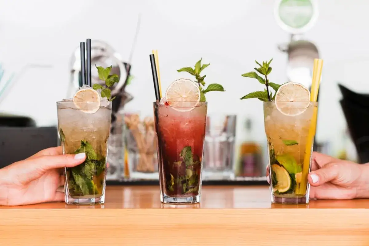 Trzy orzeźwiające mojito bezalkoholowe z miętą i limonką, gotowe do podania.