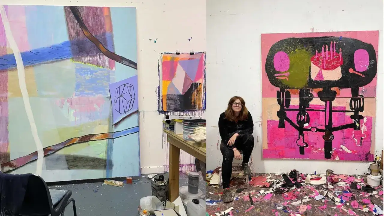 A young artist, one of the new gen z artists, sits in her studio surrounded by her vibrant, abstract paintings.