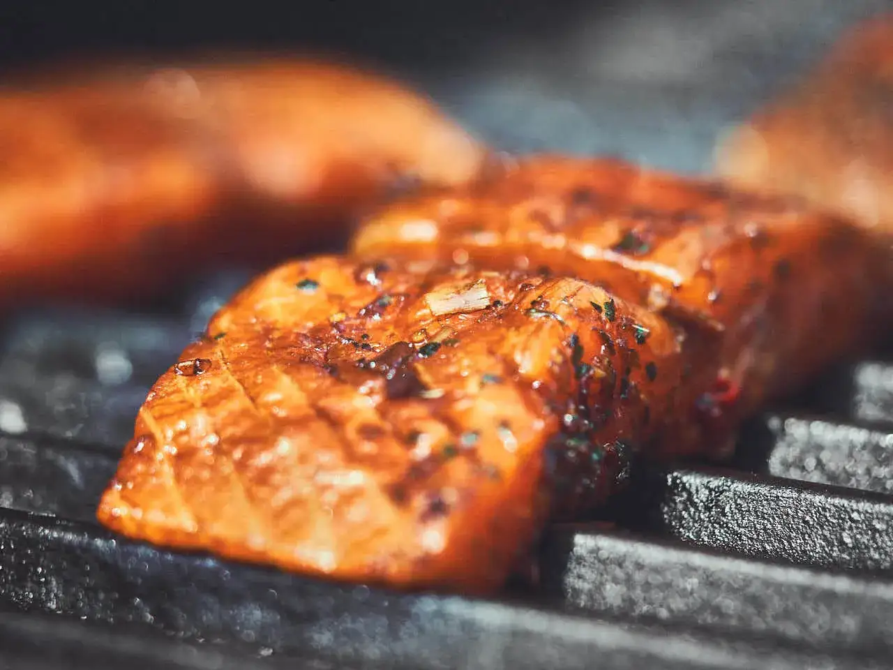 Saftige Lachsfilets mit Kr&auml;utern und Gew&uuml;rzen werden auf dem Grill zubereitet. Der Lachs grillen ist ein Genuss!