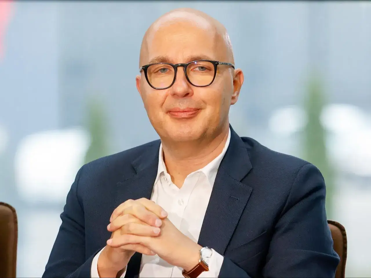 Robert Kropiwnicki, z charakterystycznym łysym łysym i okularami, w garniturze. Jego wykształcenie jest kluczowe dla jego kariery.