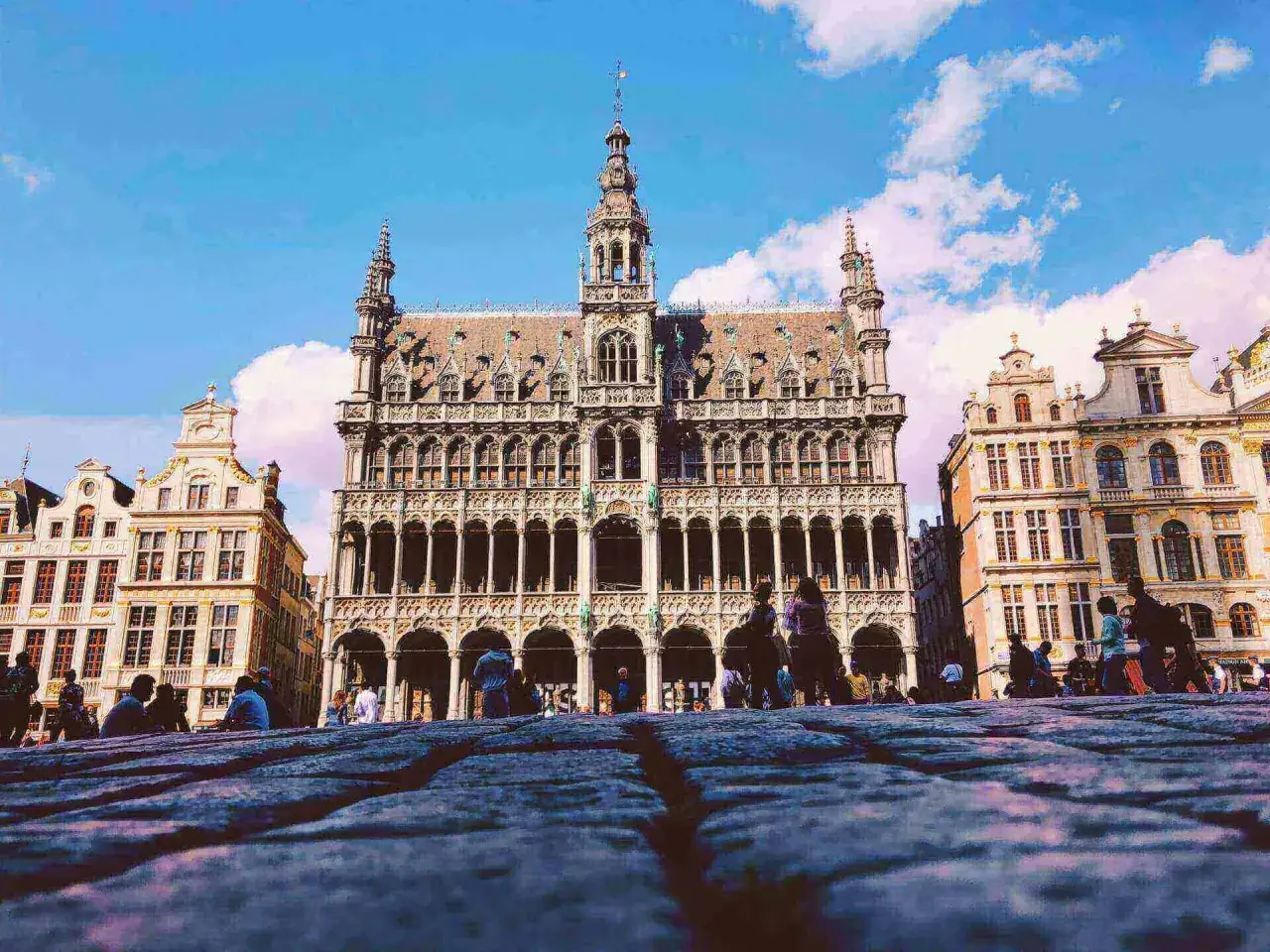 Bruksela, Grand Place. Ludzie spacerują po bruku przed zabytkowymi kamienicami. Marzenie o pracy w Belgii staje się rzeczywistością.