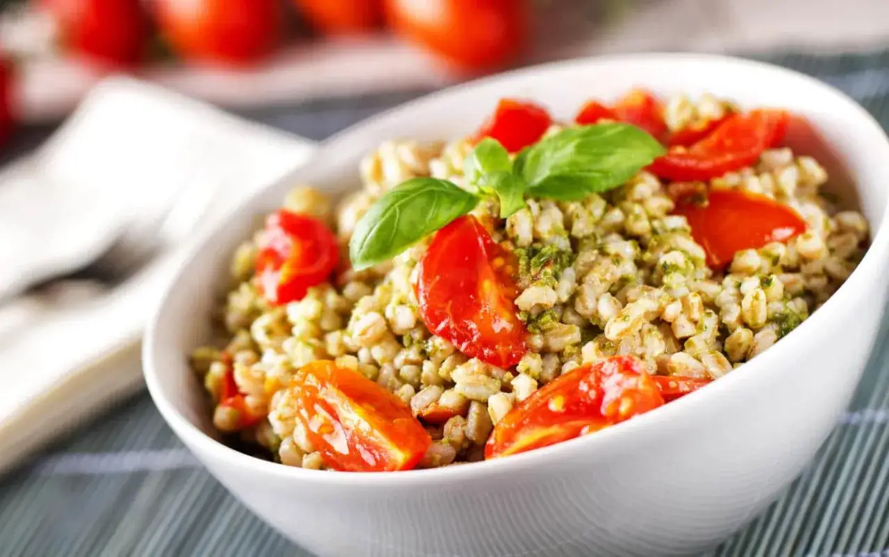 Insalata di orzo con pomodorini freschi e basilico, un piatto leggero e gustoso.