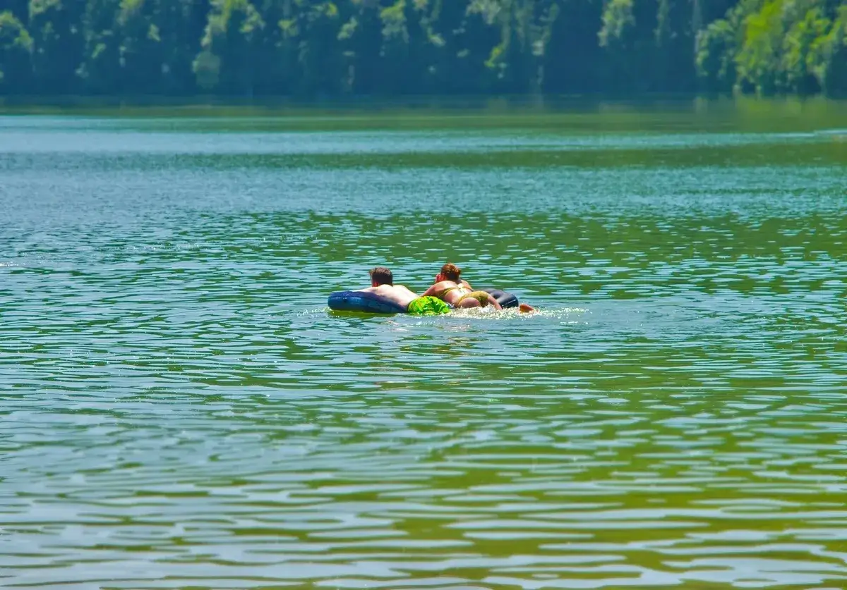 Ein Paar genie&szlig;t die Sonne auf einer Luftmatratze im **Badesee Bremen**.