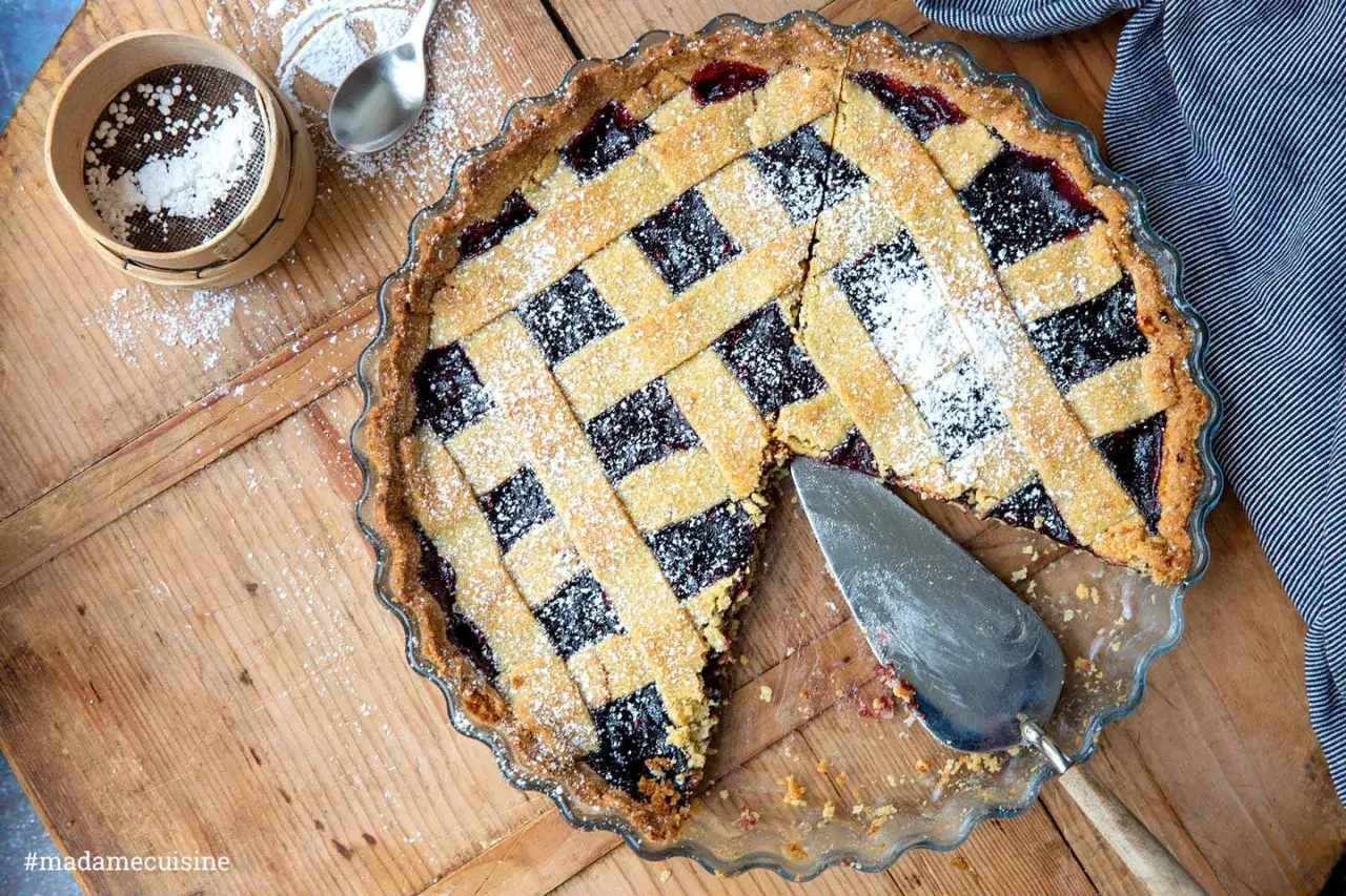 Ein köstliches Crostata Rezept mit Gittermuster, bestäubt mit Puderzucker. Perfekt für den Nachmittagskaffee.
