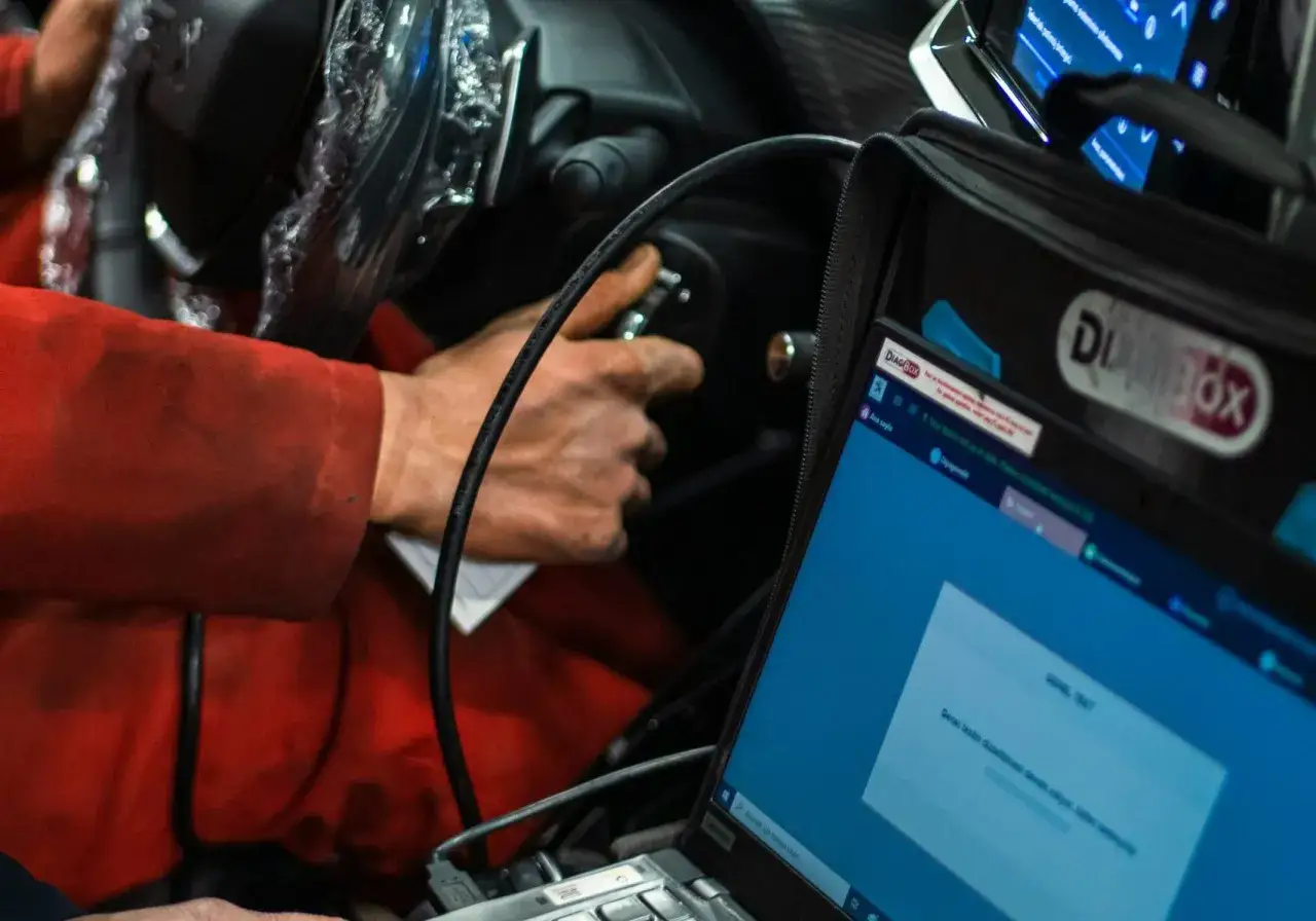 Mechanik sprawdza objawy sondy lambda za pomocą komputera diagnostycznego.