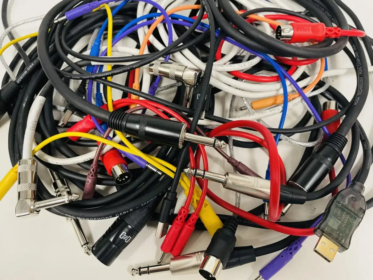Ein bunter Haufen Audiokabel mit verschiedenen Steckern. Was ist aux? Hier sind viele Kabel, die für Audioverbindungen genutzt werden.