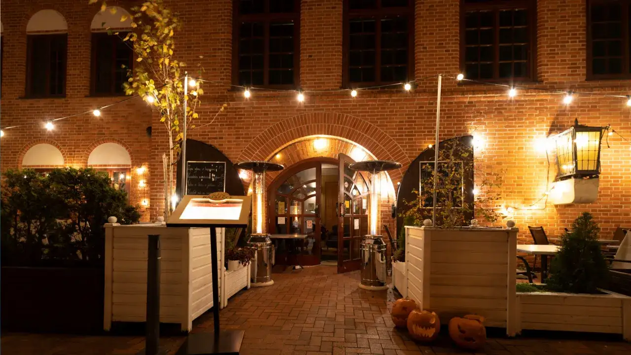 Wieczorna restauracja Filharmonia zaprasza do zapoznania się z menu. Ciepłe światła i dynie tworzą przytulną atmosferę.