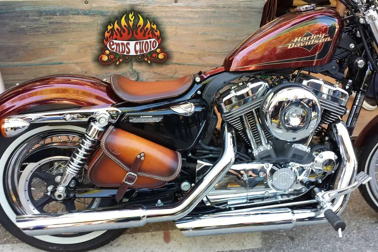 Harley-Davidson con selle personalizzate in cuoio e borsa laterale coordinata. Dettagli cromati brillanti e vernice metallizzata.