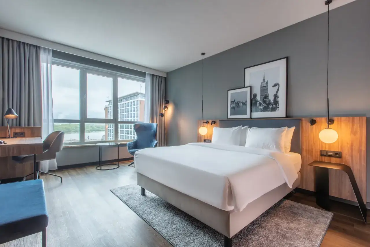 Przytulny pokój w Radisson Blu Hotel Rostock z wygodnym łóżkiem, biurkiem i widokiem na miasto.