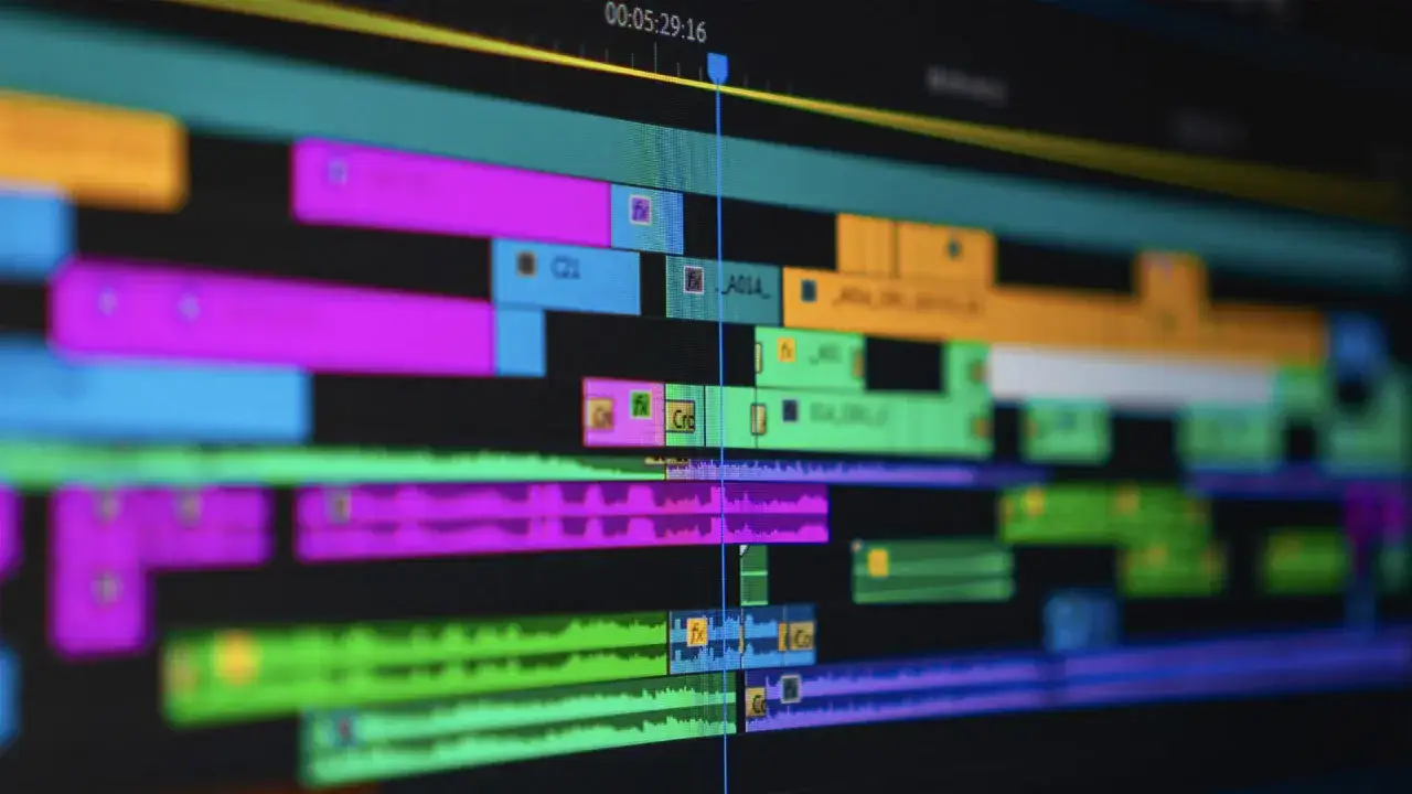 Linie czasu w programie Adobe Creative, pełne kolorowych klipów wideo i ścieżek audio, gotowe do edycji.