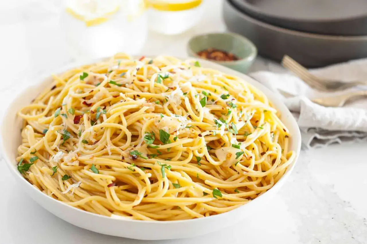 Eine Sch&uuml;ssel mit k&ouml;stlichen Spaghetti Aglio e Olio, garniert mit Petersilie und Parmesan.