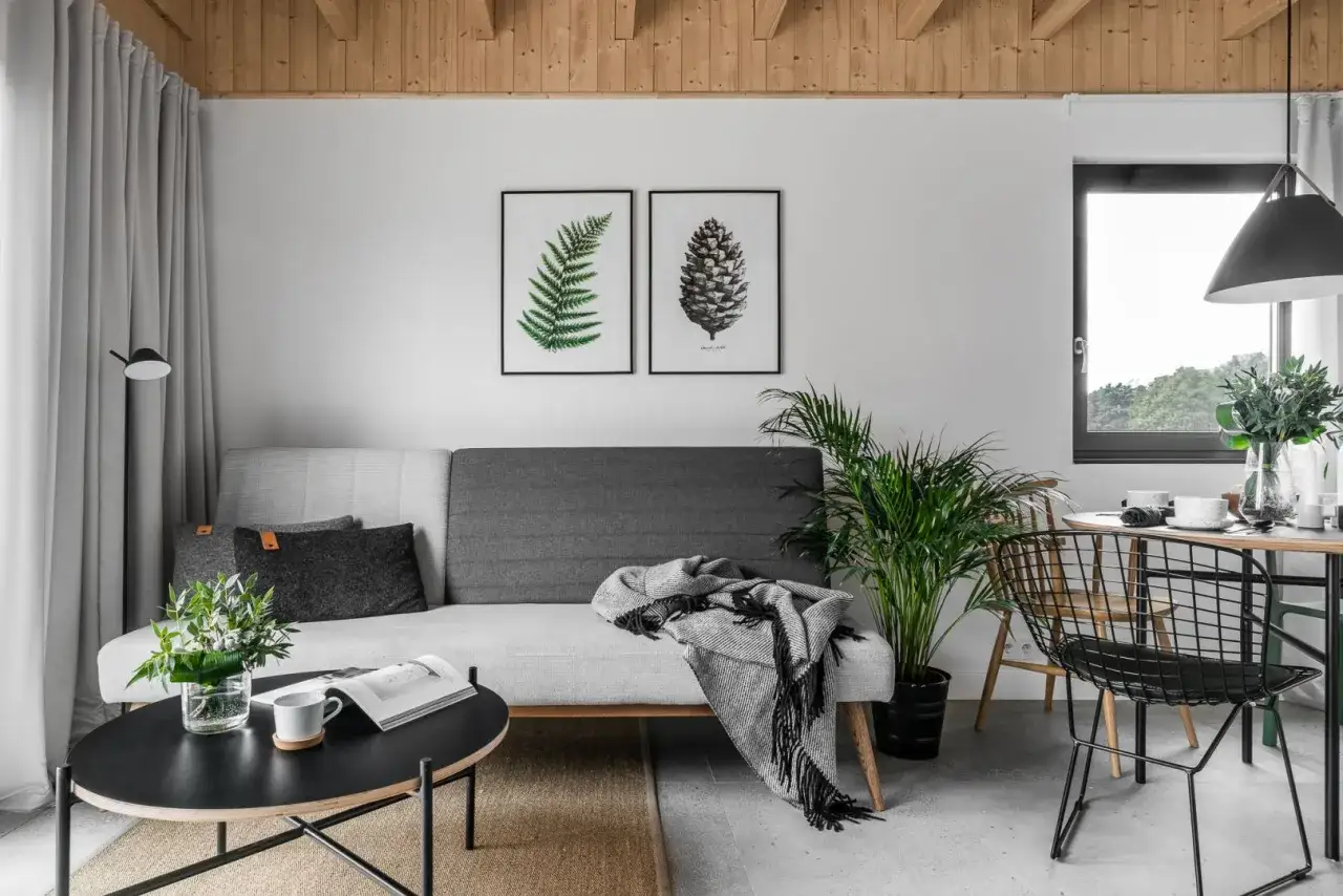 Nowoczesny salon z sofą, stolikiem kawowym i dwoma obrazami na ścianie, przypominającymi motywy z **fototapety IKEA**.