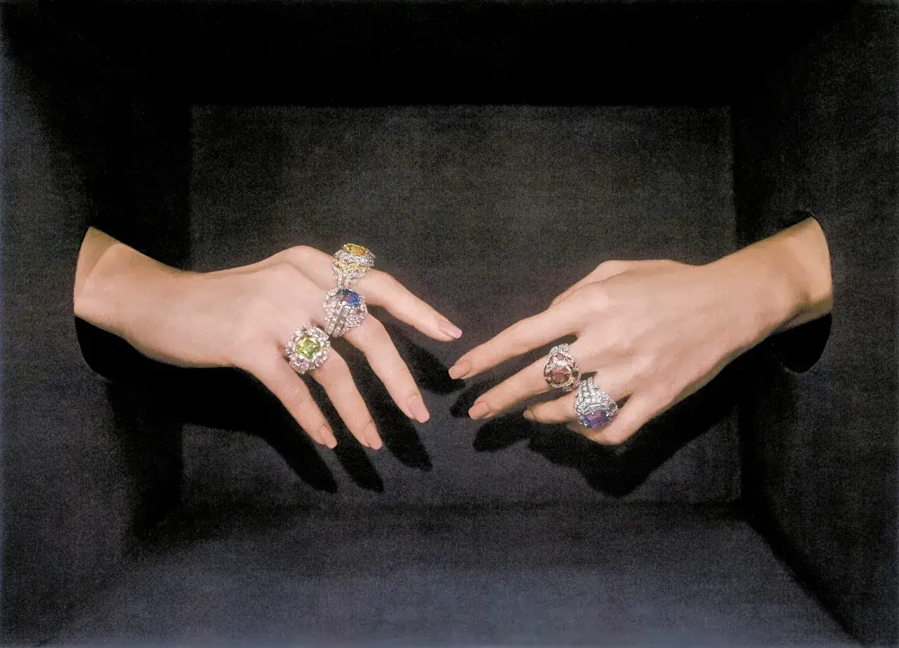 Mani adornate con anelli preziosi, un'esplosione di gemme colorate che evocano la creatività di Delfina Delettrez per Fendi.