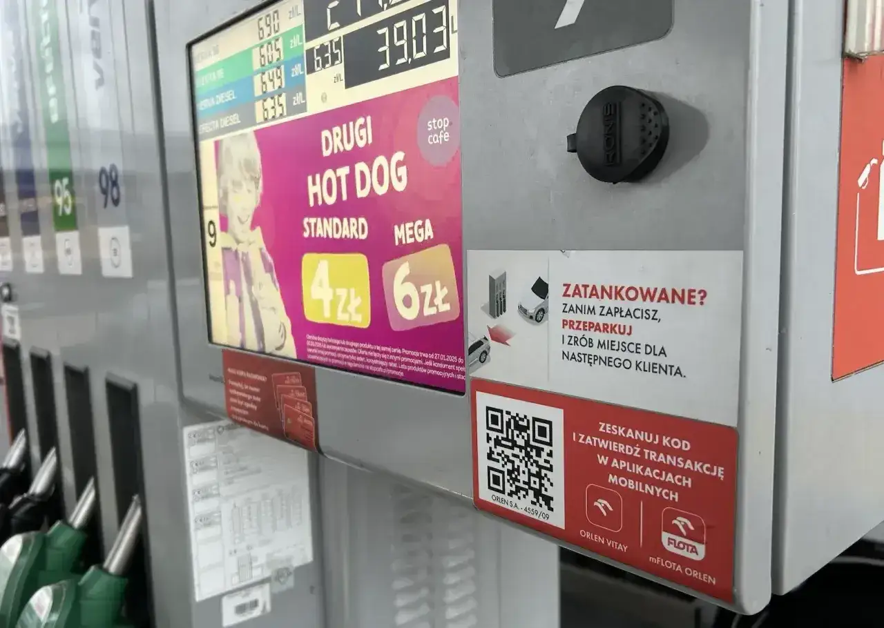 Na dystrybutorze Orlen widać ceny paliw, promocję na hot dogi oraz instrukcję płatności mobilnych.