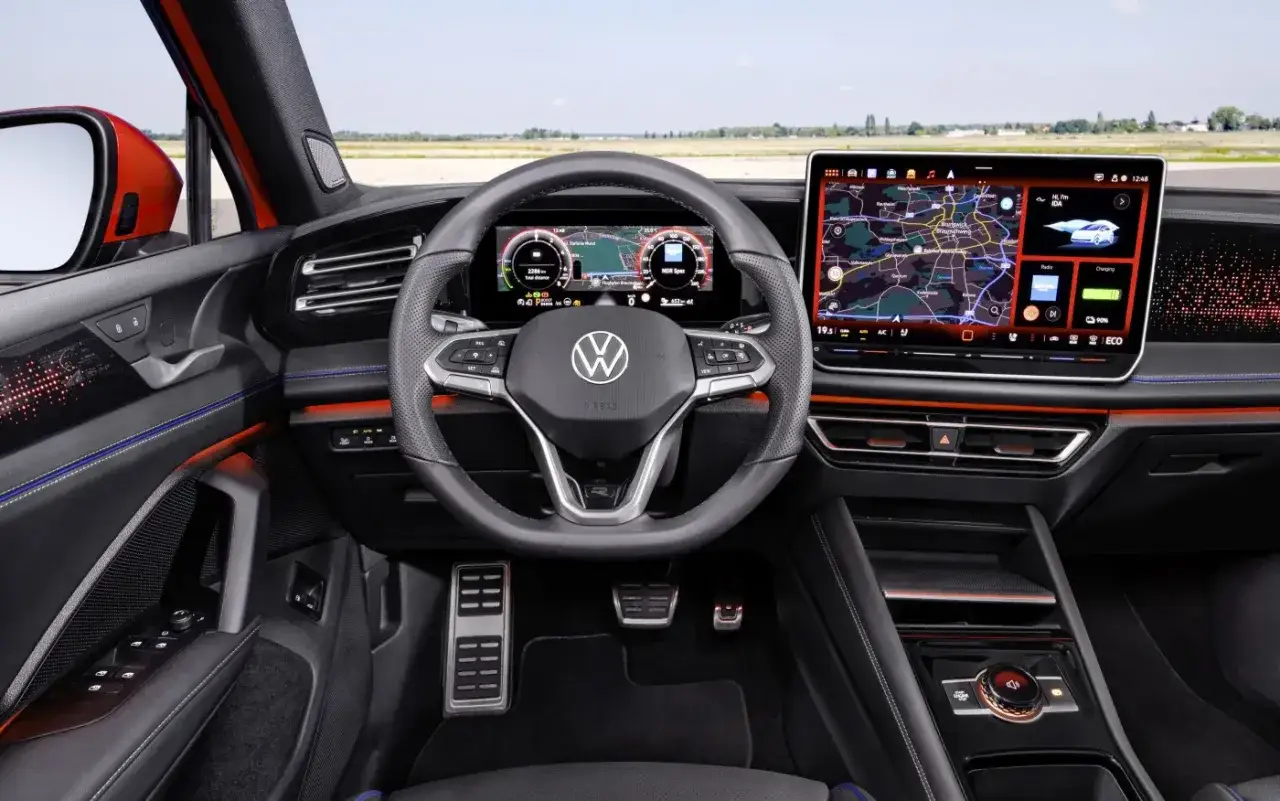 Wnętrze nowoczesnego Volkswagena Tiguan 2019 z cyfrowymi ekranami, nawigacją i sportową kierownicą.