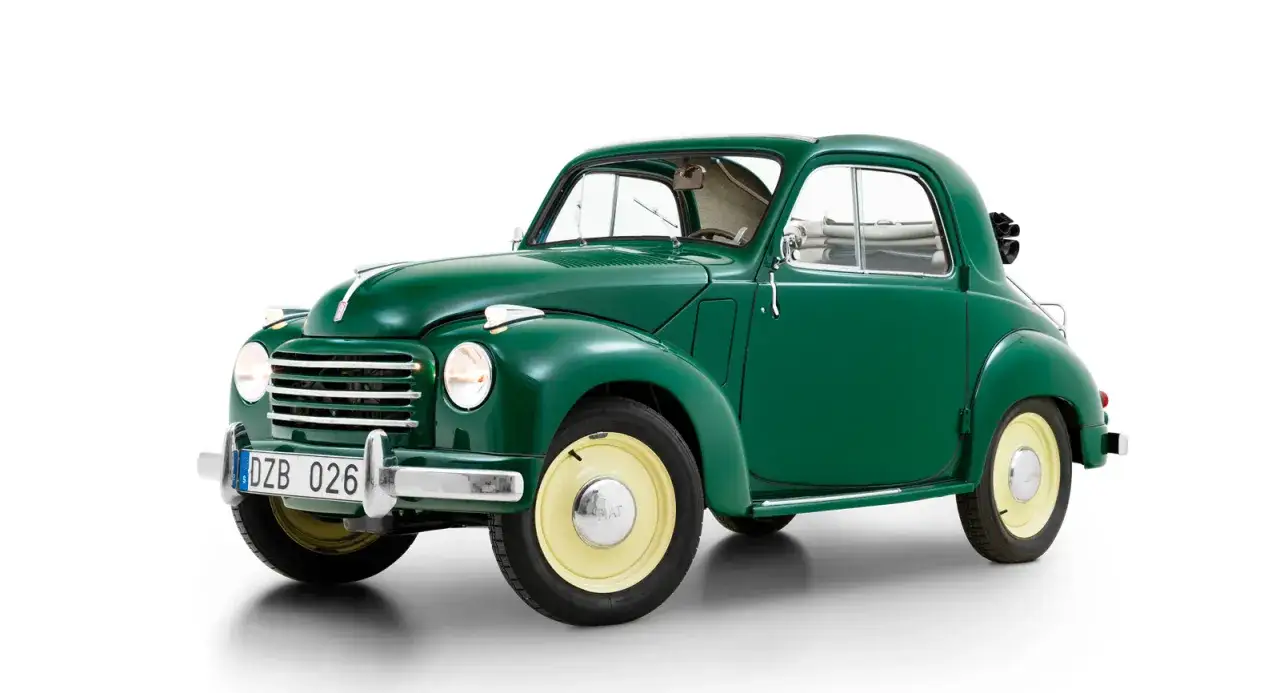 Grön Fiat 500 Topolino från 1949 med gula fälgar. En klassisk liten bil som väcker nostalgi.
