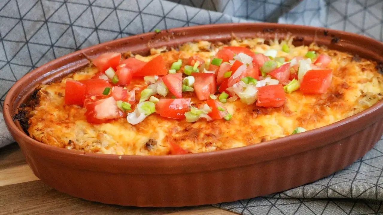 Herzhafter blumenkohlauflauf mit hackfleisch, &uuml;berbacken mit K&auml;se und garniert mit frischen Tomaten und Fr&uuml;hlingszwiebeln.