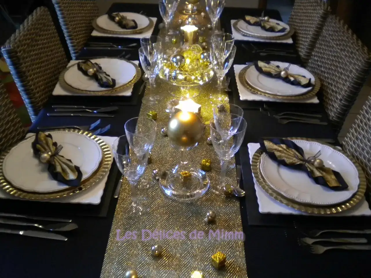 Une table &eacute;l&eacute;gante pour organiser une soir&eacute;e de nouvel an. Nappage dor&eacute;, vaisselle chic, bougies et ornements scintillants pour un r&eacute;veillon festif.