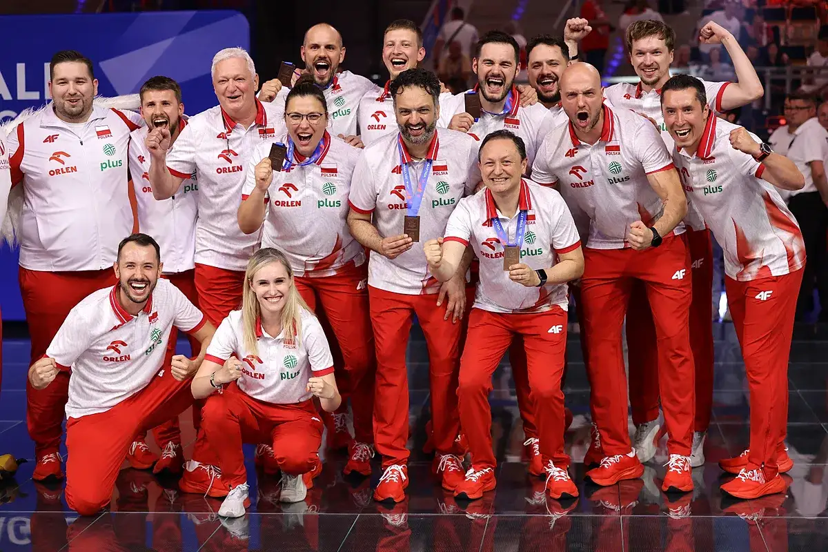 Radosna reprezentacja kobiet w siatkówce świętuje sukces, dumnie prezentując medale.