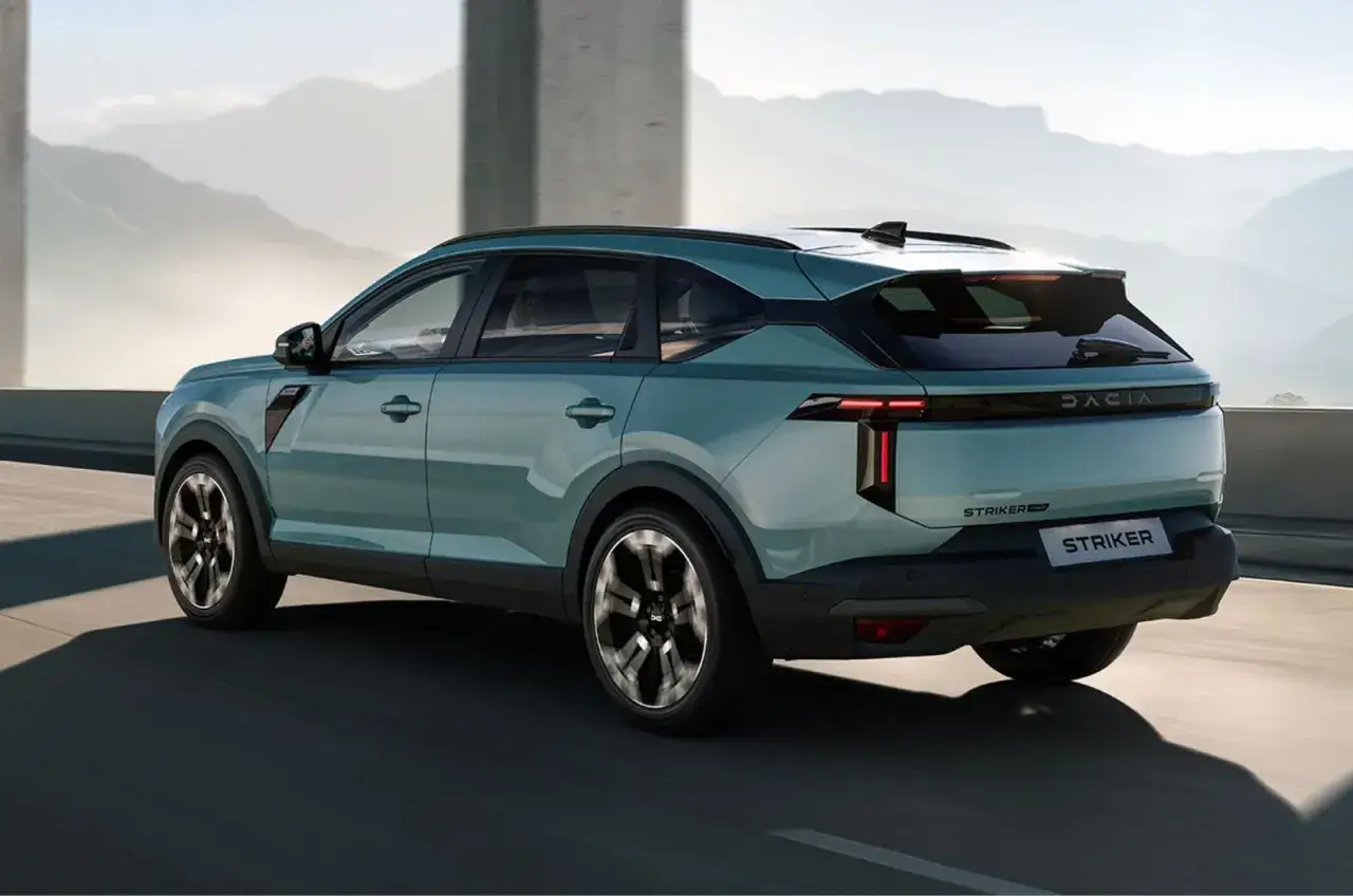 Dacia c neo, un SUV moderno color acquamarina, sfreccia su una strada panoramica tra montagne nebbiose.