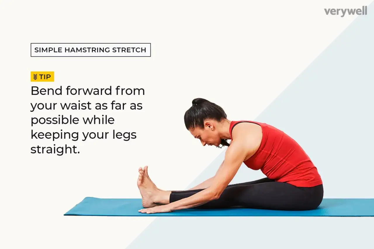 En kvinna stretchar baksida lår på en yogamatta. Hon sitter med raka ben och böjer sig framåt från midjan.