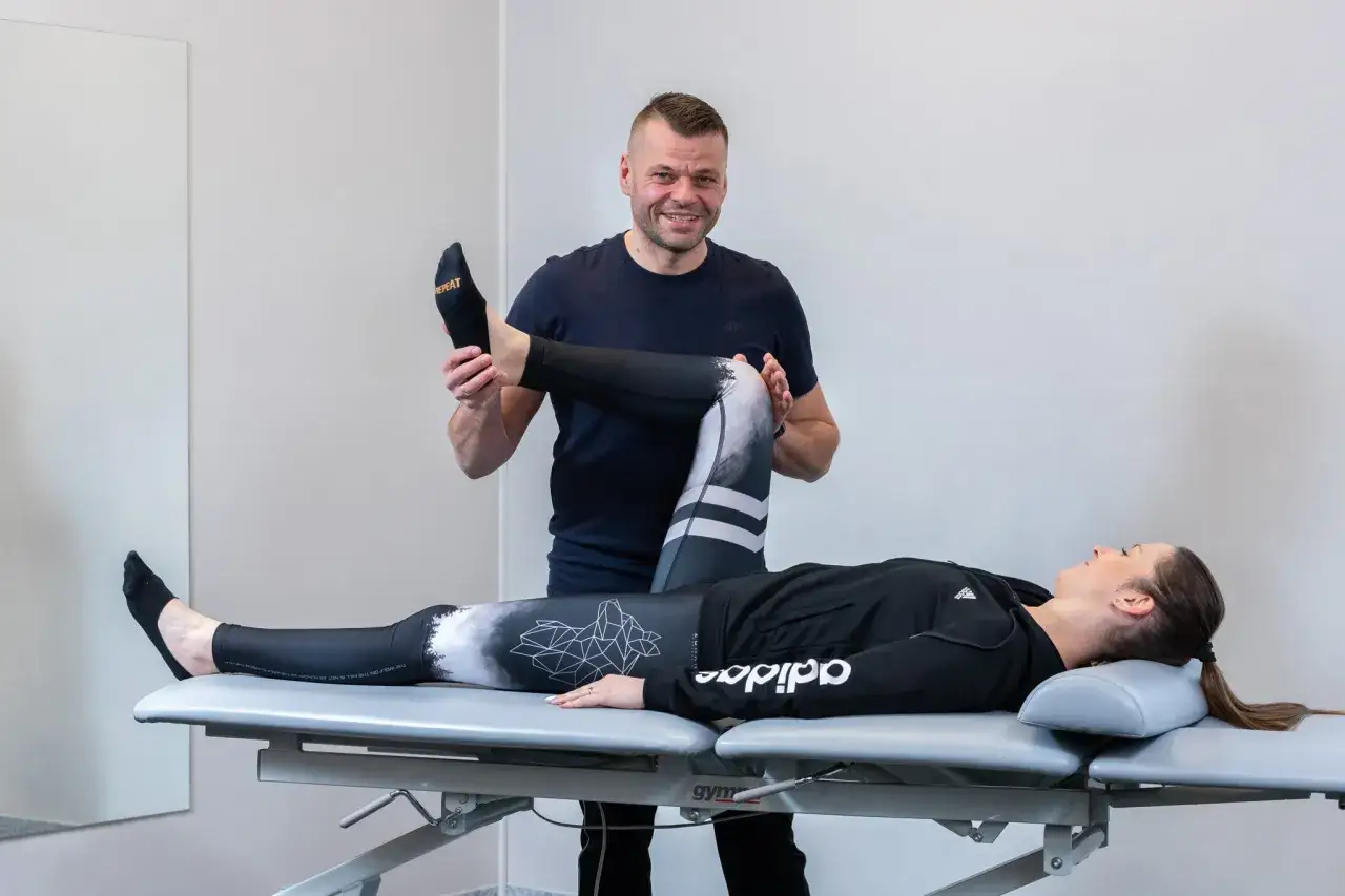Fizjoterapeuta pomaga pacjentce z problemem acl w rehabilitacji.