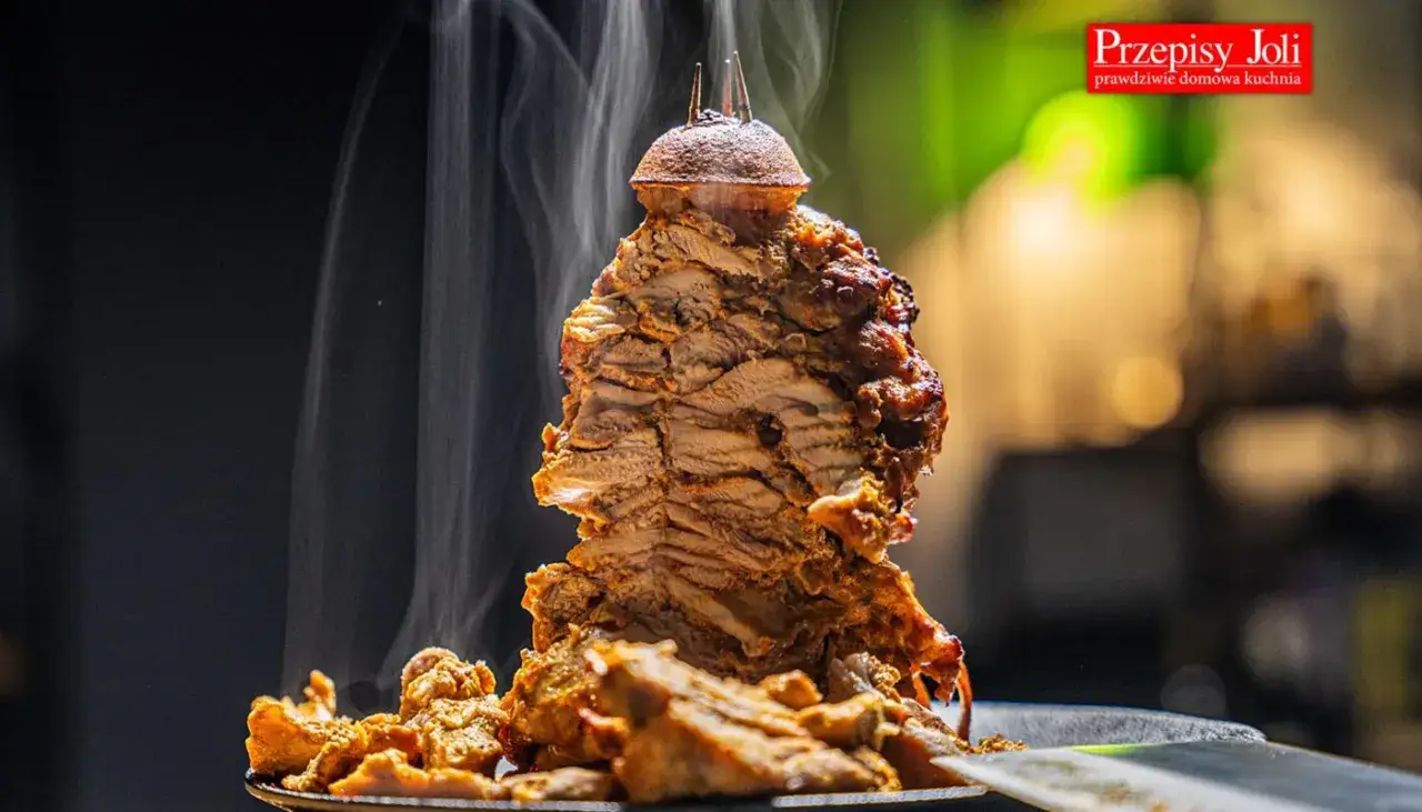 Pyszny, parujący kebab z piekarnika, soczyste mięso skrawane z pionowego rożna, gotowe do podania.