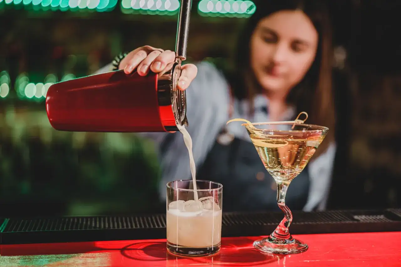 Barmanka przygotowuje drinki. Idealne miejsca na wieczór panieński, gdzie można celebrować w dobrym stylu.